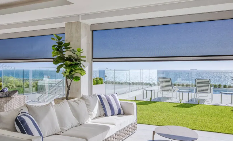 Outdoor blinds lowered behind an outdoor lounge setting
