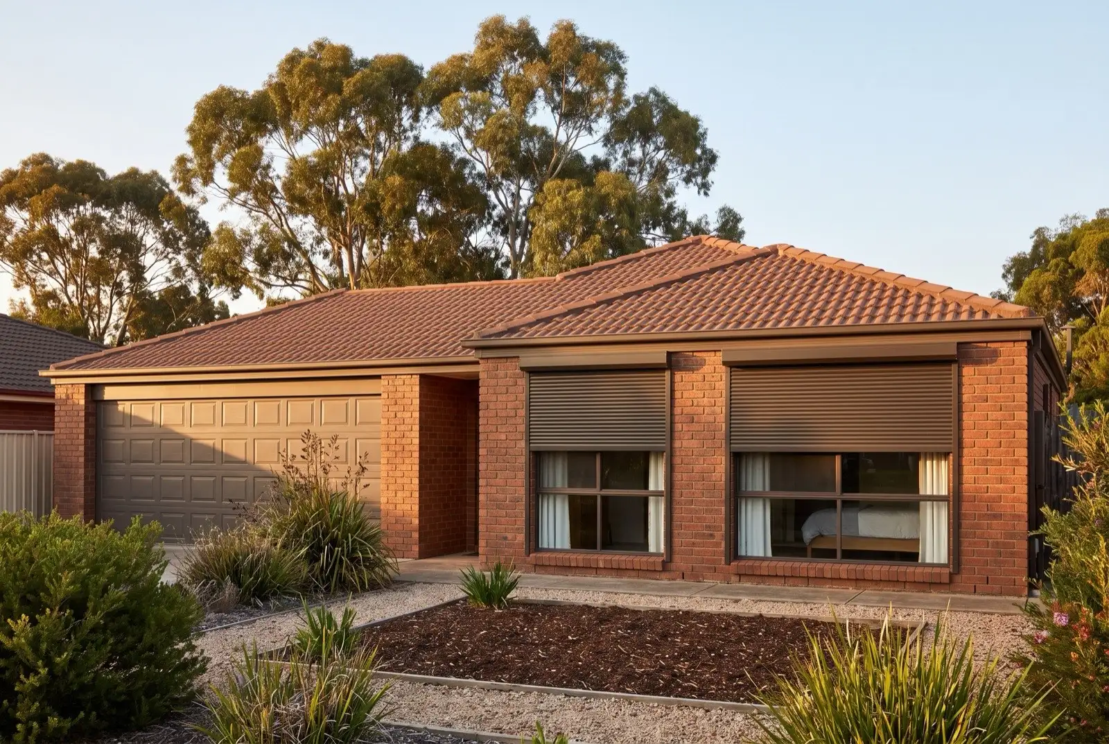 Illustration of dark bronze roller shutters on a 1990s brick house on a bush block