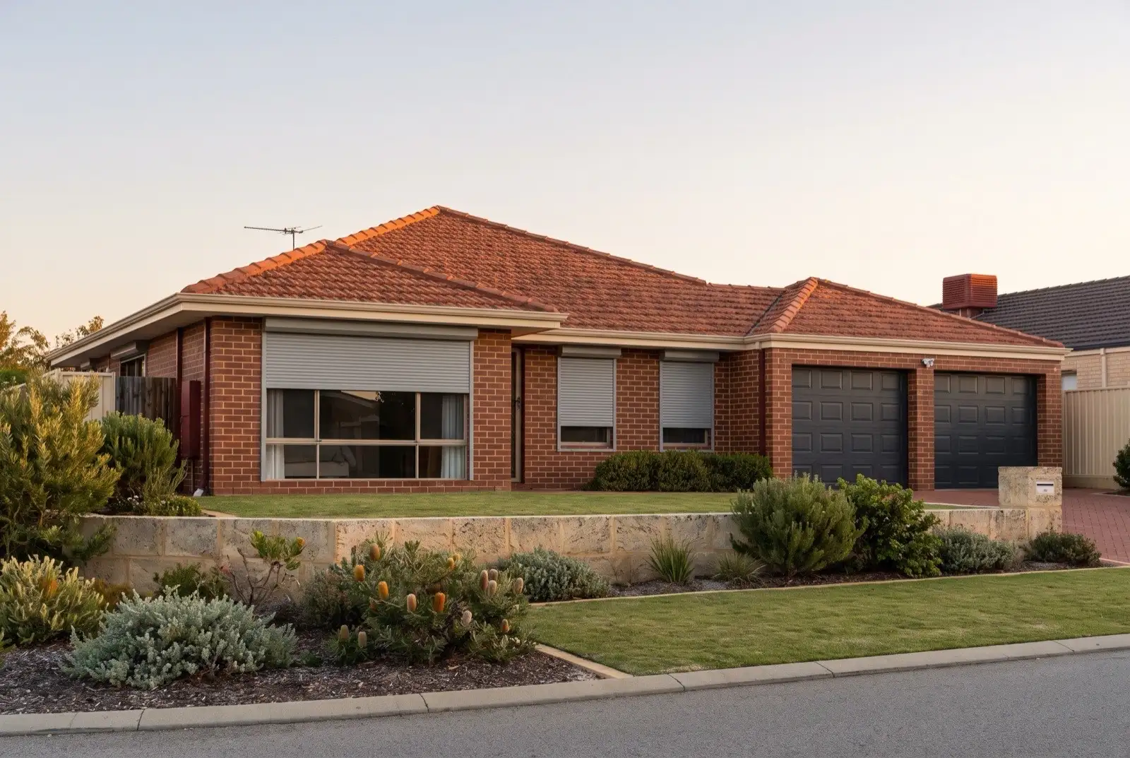 Illustration of mid grey roller shutters on a 1990s brick house near the coast