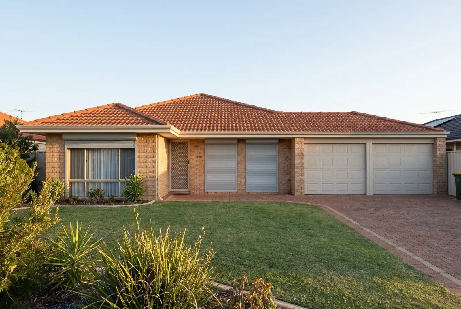 Illustration of pale grey roller shutters on a 1990s brick house