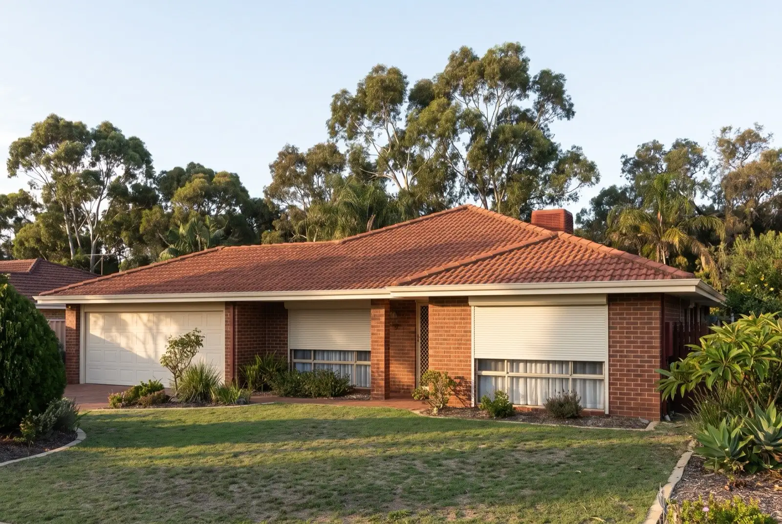 Illustration of off-white roller shutters on a 1990s brick house on a bush block