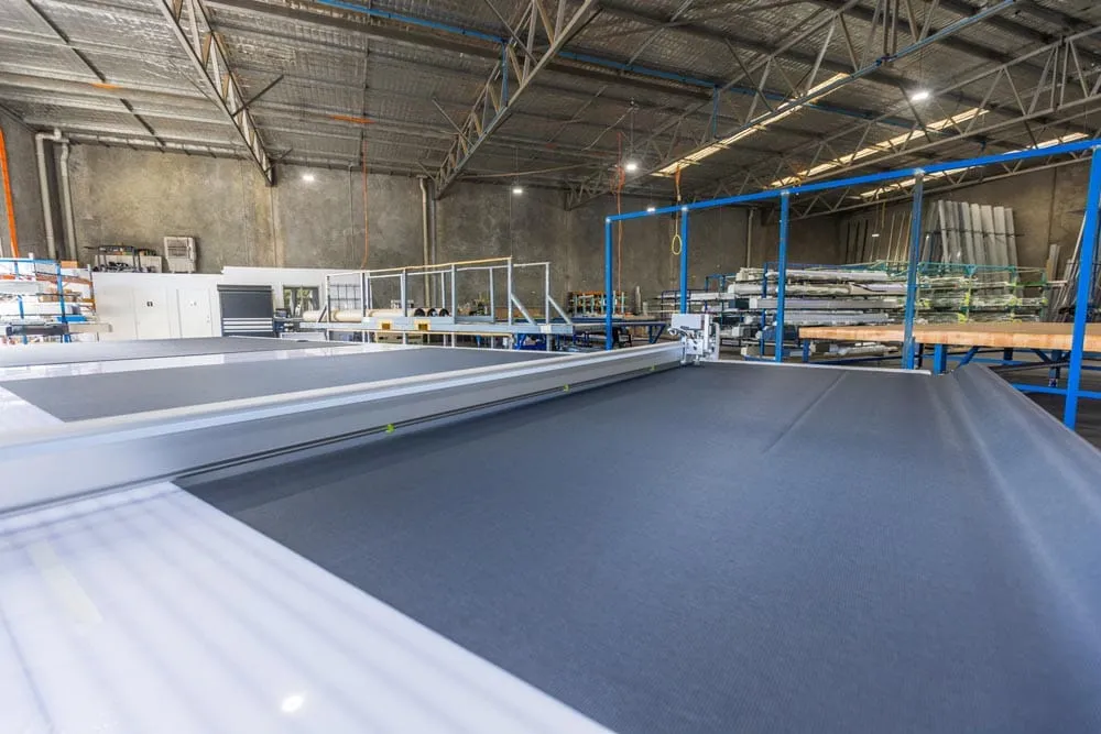Grey mesh outdoor blind fabric on the cutting table in the Wangara factory