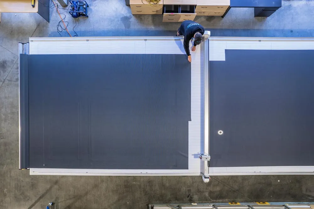 Large outdoor blind panels laid out for assembly on the factory table, viewed from above