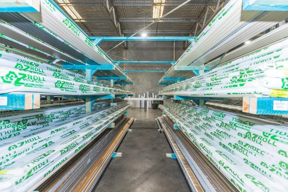 Aisle of Ozroll-wrapped roller shutter extrusions racked in the Wangara factory