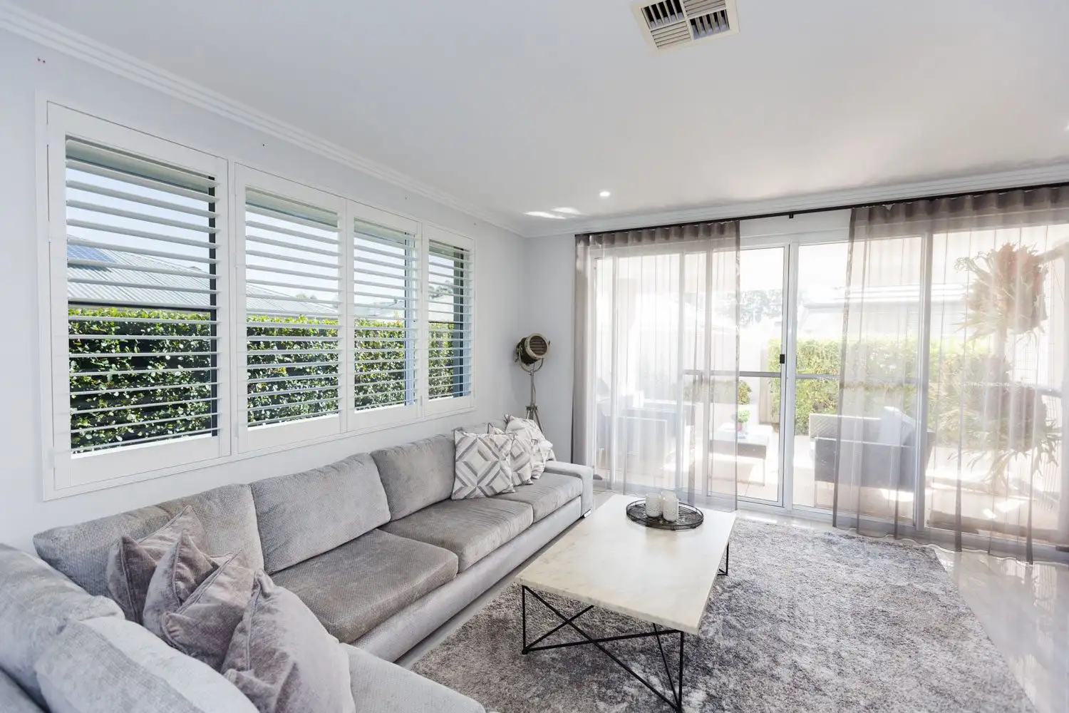 White plantation shutters with the louvres tilted open in a Perth living room