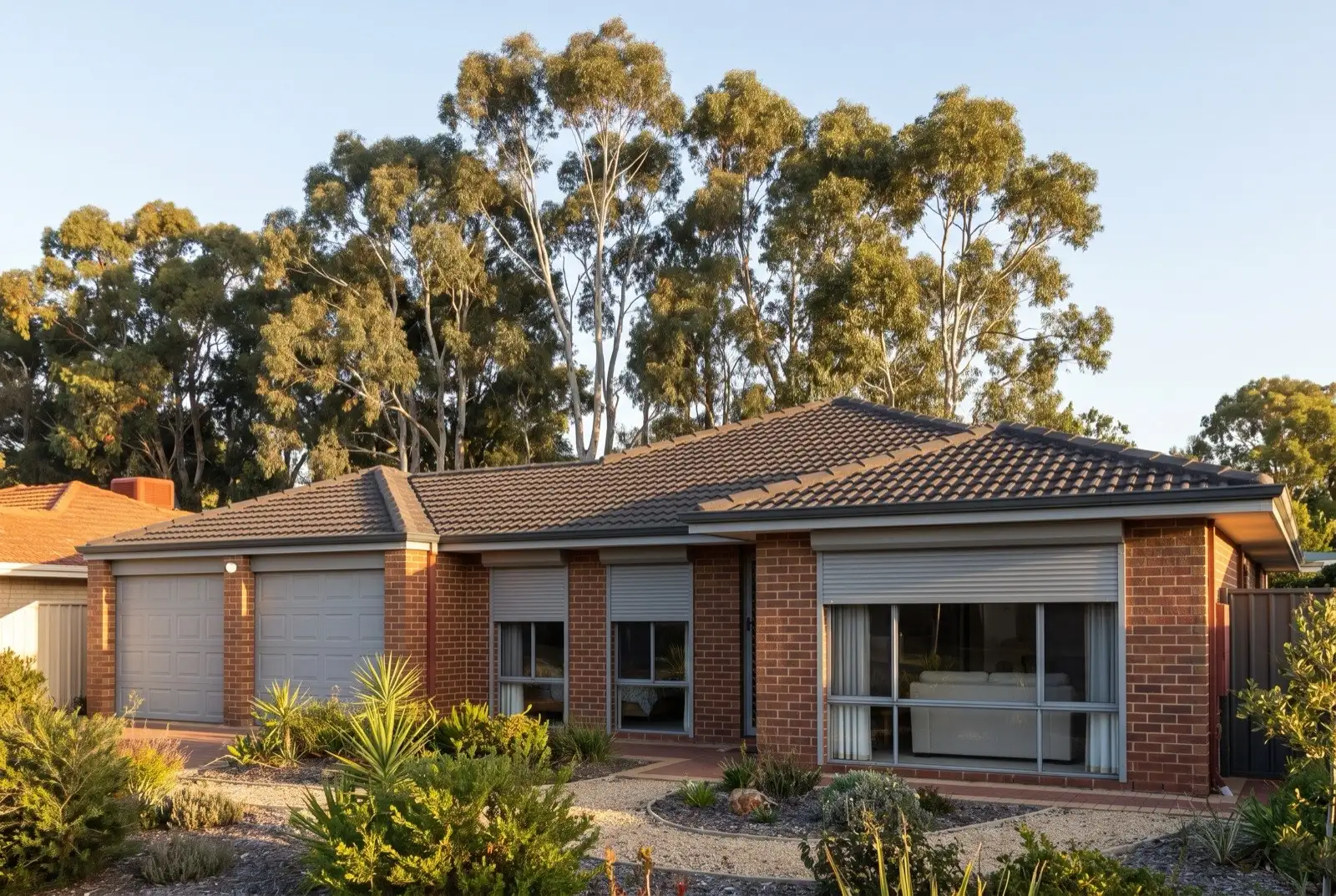Illustration of mid grey roller shutters on a 1990s brick house on a bush block