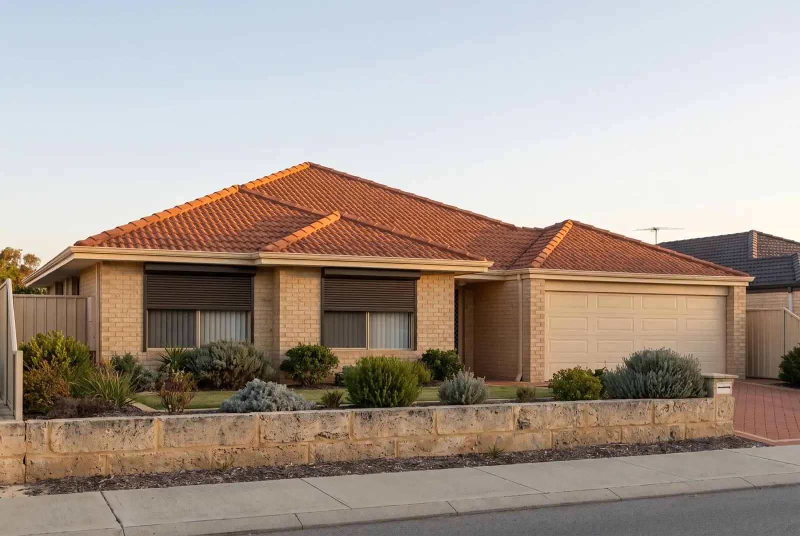 Illustration of dark bronze roller shutters on a 1990s brick house near the coast