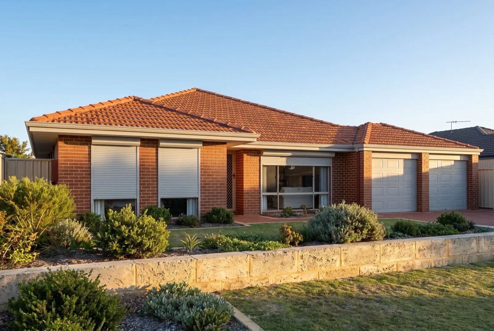 Illustration of pale grey roller shutters on a 1990s brick house near the coast