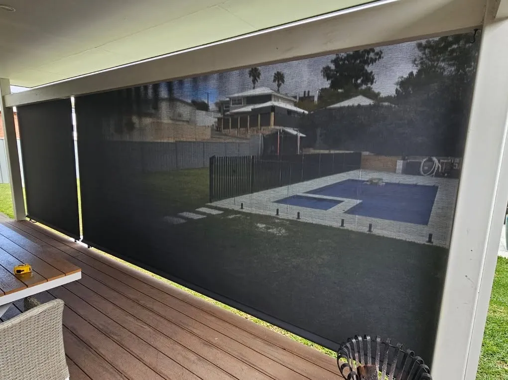 Black mesh Slidetrack blind on a decked alfresco overlooking a pool