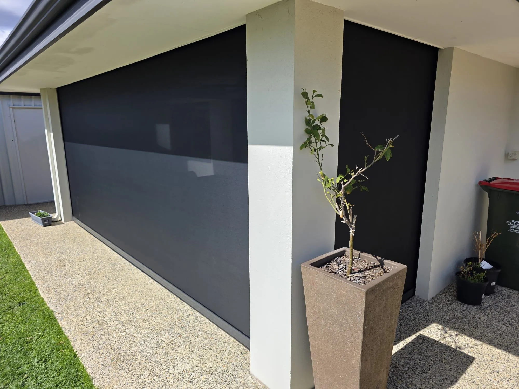 Charcoal Slidetrack blind beside a concrete planter on a modern Perth home