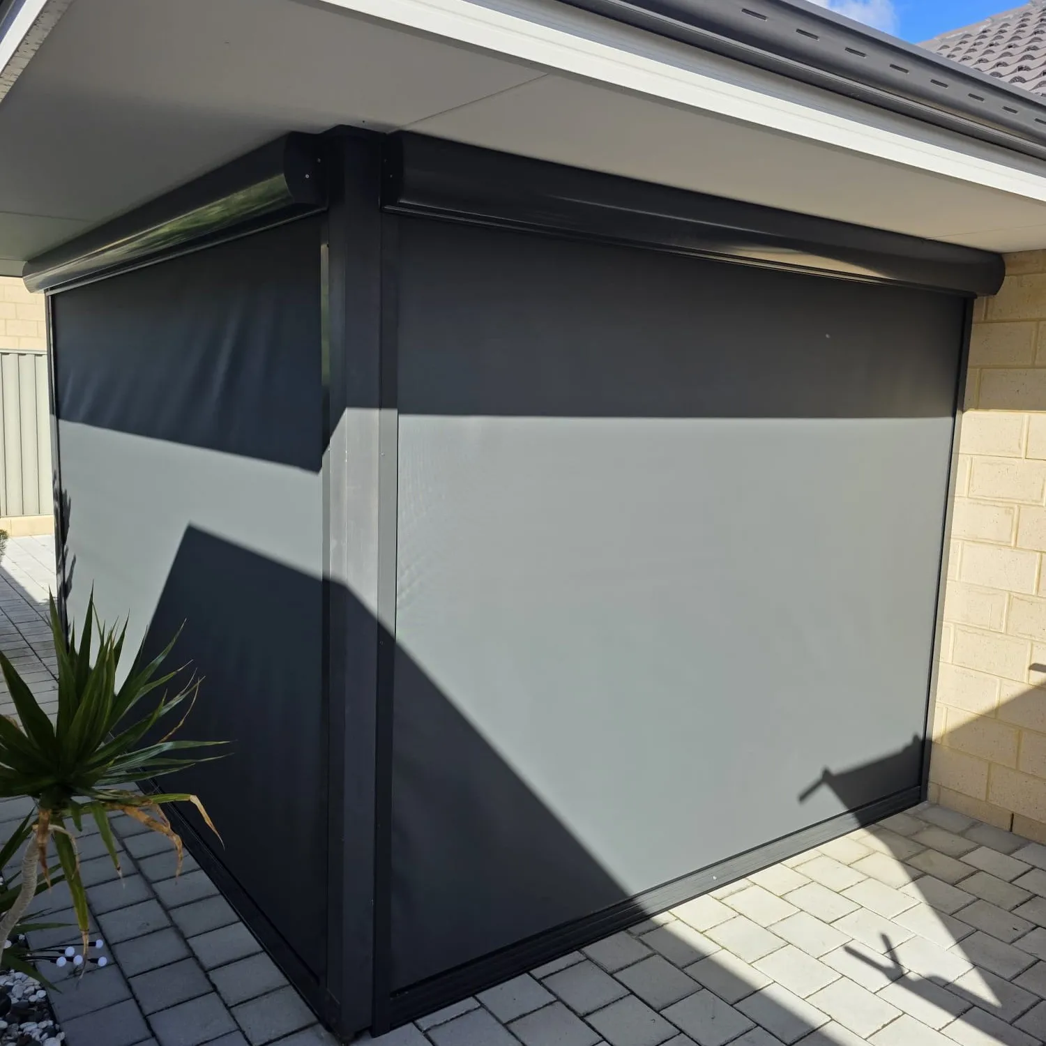Grey and charcoal Slidetrack blinds on a paved alfresco corner