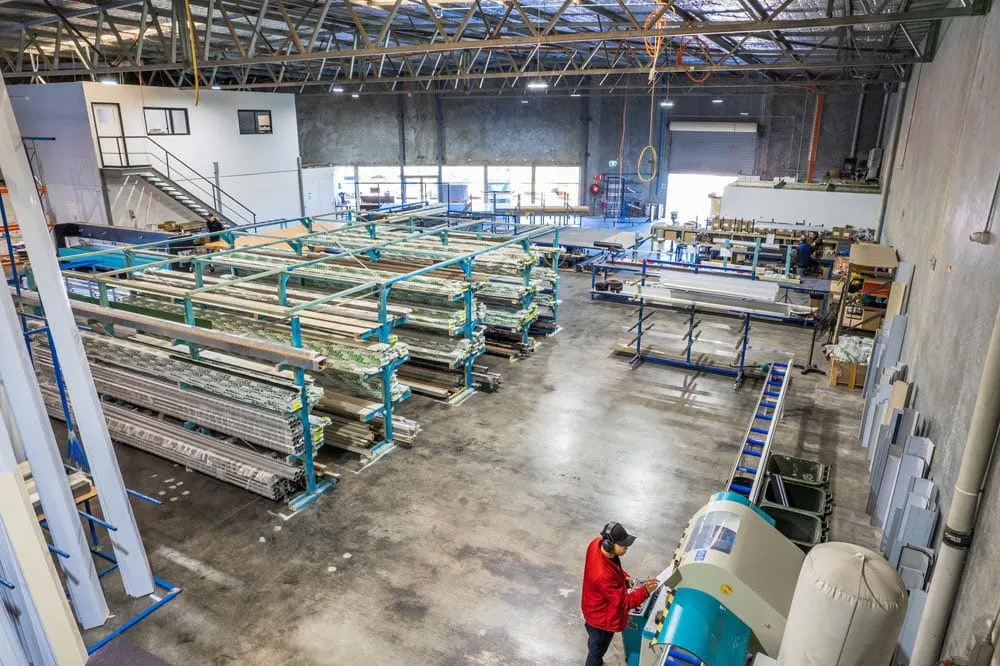 Racks of aluminium extrusions and roller shutter stock on the factory floor